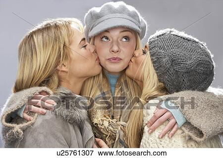 Three Teenage Girls Wearing Cap And Knitwear In Studio Giving Each Other Kiss View Large Photo Image Stock Photo - Three Teenage Girls Wearing Cap And Knitwear In Studio Giving Each Other Kiss. Fotosearch