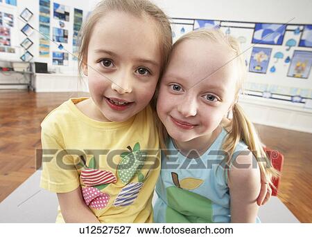 Stock Photo - Two Female Primary Schoolchildren In Classroom. Fotosearch