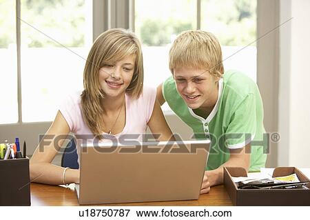 Stock Photo - Two Teenagers Using Laptop At Home. Fotosearch