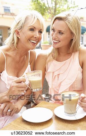 Stock Image - Two Women Enjoying Cup Of Coffee In Café. Fotosearch
