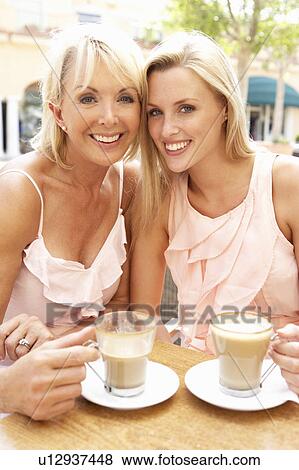 Stock Photo - Two Women Enjoying Cup Of Coffee In Café. Fotosearch