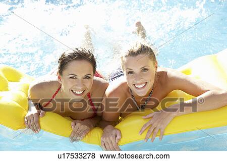 Two women friends having fun together in pool View Large Photo Image Stock Photo - Two women friends having fun together in pool. Fotosearch