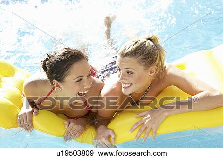 Two women friends having fun together in pool View Large Photo Image Stock Photo - Two women friends having fun together in pool. Fotosearch