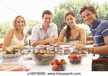 Two young couples eating outdoors View Large Photo Image Stock Image - Two young couples eating outdoors. Fotosearch