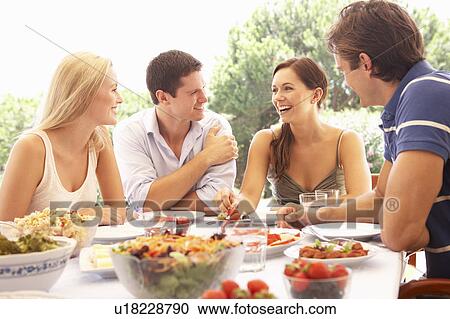 Two young couples eating outdoors View Large Photo Image Stock Image - Two young couples eating outdoors. Fotosearch