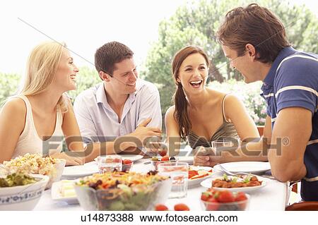 Two young couples eating outdoors View Large Photo Image Stock Photo - Two young couples eating outdoors. Fotosearch
