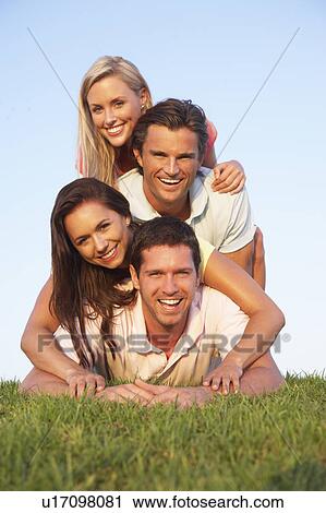 Two, young couples posing on a field View Large Photo Image Stock Image - Two, young couples posing on a field. Fotosearch