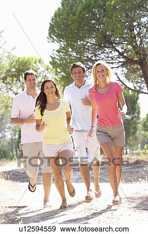 Two young couples, together, running in park View Large Photo Image Stock Photo - Two young couples, together, running in park. Fotosearch