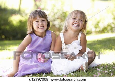 Stock Photo - Two young girls posing in park. Fotosearch