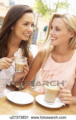Two Young Women Enjoying Cup Of Coffee In Café View Large Photo Image Stock Image - Two Young Women Enjoying Cup Of Coffee In Café. Fotosearch