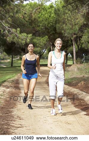 Two young women running in park View Large Photo Image Stock Photo - Two young women running in park. Fotosearch
