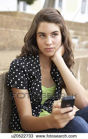Unhappy Female Teenage Student Sitting Outside On College Steps Using Mobile Phone View Large Photo Image Stock Image - Unhappy Female Teenage Student Sitting Outside On College Steps Using Mobile Phone. Fotosearch