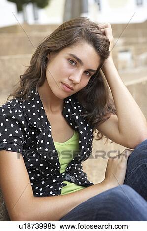 Stock Photography - Unhappy Female Teenage Student Sitting Outside On College Steps Using Mobile Phone. Fotosearch