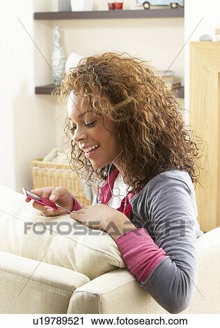 Woman Listening To MP3 Player On Headphones Relaxing Sitting On Rug At Home View Large Photo Image Stock Image - Woman Listening To MP3 Player On Headphones Relaxing Sitting On Rug At Home . Fotosearch