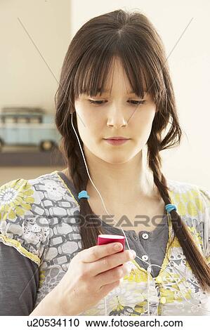 Woman Listening To MP3 Player On Headphones Relaxing Sitting On Rug At Home View Large Photo Image Stock Image - Woman Listening To MP3 Player On Headphones Relaxing Sitting On Rug At Home . Fotosearch