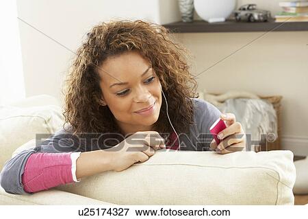 Woman Listening To MP3 Player On Headphones Relaxing Sitting On Rug At Home View Large Photo Image Stock Photo - Woman Listening To MP3 Player On Headphones Relaxing Sitting On Rug At Home . Fotosearch