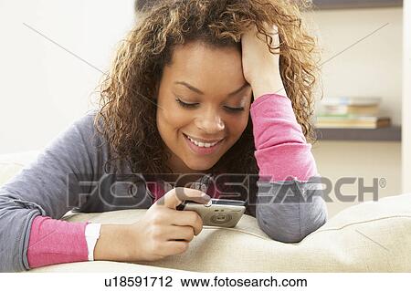 Woman Looking At Pictures On Digital Camera Relaxing Sitting On Sofa At Home View Large Photo Image Stock Image - Woman Looking At Pictures On Digital Camera Relaxing Sitting On Sofa At Home. Fotosearch