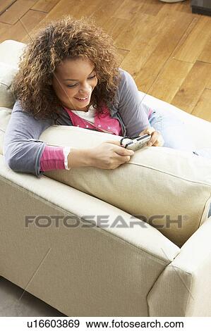 Woman Looking At Pictures On Digital Camera Relaxing Sitting On Sofa At Home View Large Photo Image Stock Photo - Woman Looking At Pictures On Digital Camera Relaxing Sitting On Sofa At Home. Fotosearch