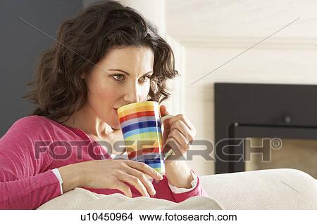 Woman Relaxing On Sofa At Home Drinking Cup Of Coffee View Large Photo Image Picture - Woman Relaxing On Sofa At Home Drinking Cup Of Coffee. Fotosearch