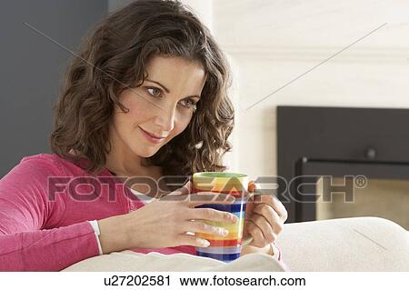 Woman Relaxing On Sofa At Home Drinking Cup Of Coffee View Large Photo Image Stock Image - Woman Relaxing On Sofa At Home Drinking Cup Of Coffee. Fotosearch