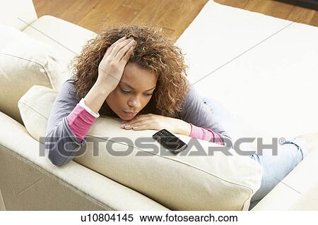 Woman Sitting On Sofa Wating For Mobile Phone At Home View Large Photo Image Stock Photography - Woman Sitting On Sofa Wating For Mobile Phone At Home . Fotosearch