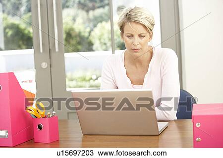 Stock Image - Woman Using Laptop At Home. Fotosearch