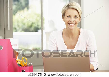 Stock Image - Woman Using Laptop At Home. Fotosearch