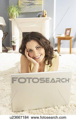 Woman Using Laptop Relaxing Laying On Rug At Home View Large Photo Image Picture - Woman Using Laptop Relaxing Laying On Rug At Home . Fotosearch