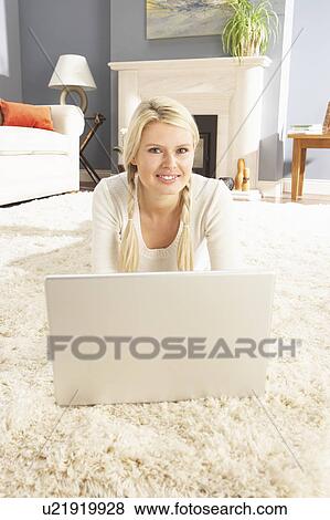 Woman Using Laptop Relaxing Laying On Rug At Home View Large Photo Image Stock Photo - Woman Using Laptop Relaxing Laying On Rug At Home . Fotosearch