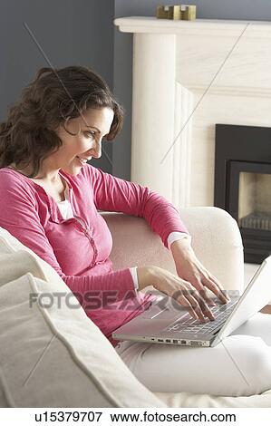 Woman Using Laptop Relaxing Sitting On Sofa At Home View Large Photo Image Stock Photo - Woman Using Laptop Relaxing Sitting On Sofa At Home . Fotosearch