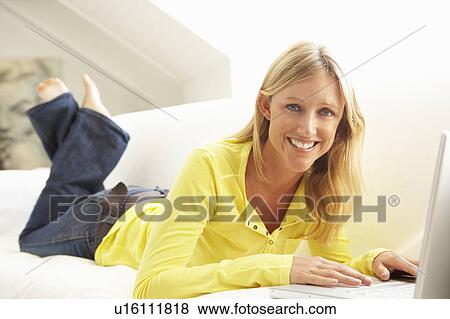 Woman Using Laptop Relaxing Sitting On Sofa At Home View Large Photo Image Stock Photo - Woman Using Laptop Relaxing Sitting On Sofa At Home. Fotosearch