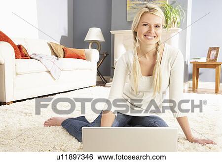 Woman Using Laptop Relaxing Sitting On Rug At Home View Large Photo Image Stock Photograph - Woman Using Laptop Relaxing Sitting On Rug At Home . Fotosearch