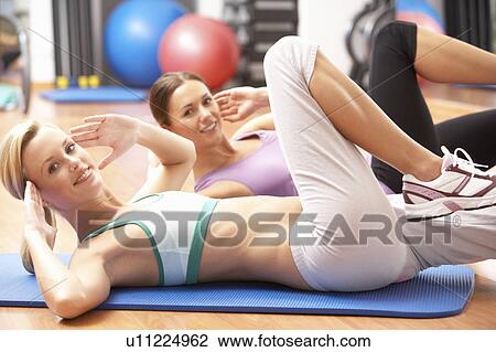 Stock Image - Women Doing Stretching Exercises In Gym. Fotosearch