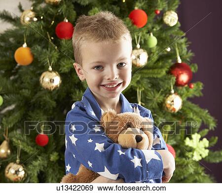 Young Boy Cuddling Teddy Bear In Front Of Christmas Tree View Large Photo Image Stock Photo - Young Boy Cuddling Teddy Bear In Front Of Christmas Tree. Fotosearch