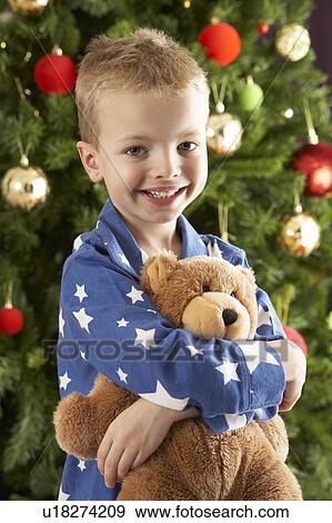 Young Boy Cuddling Teddy Bear In Front Of Christmas Tree View Large Photo Image Stock Photo - Young Boy Cuddling Teddy Bear In Front Of Christmas Tree. Fotosearch