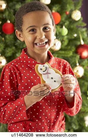 Young Boy Eating Cookie In Front Of Christmas Tree View Large Photo Image Stock Photo - Young Boy Eating Cookie In Front Of Christmas Tree. Fotosearch