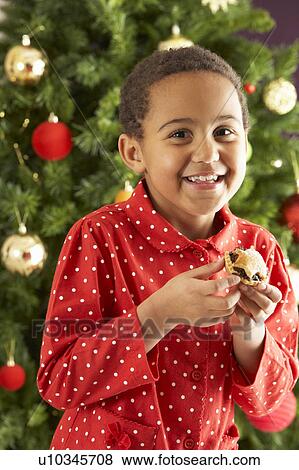 Young Boy Eating Mince Pie In Front Of Christmas Tree View Large Photo Image Stock Photo - Young Boy Eating Mince Pie In Front Of Christmas Tree. Fotosearch