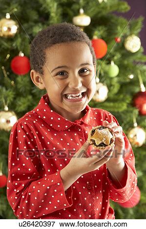 Young Boy Eating Mince Pie In Front Of Christmas Tree View Large Photo Image Stock Photo - Young Boy Eating Mince Pie In Front Of Christmas Tree. Fotosearch