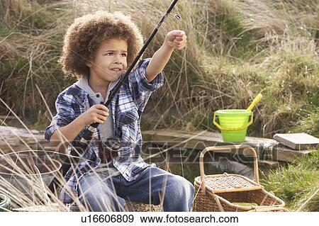 Stock Photo - Young Boy Fishing At Seaside. Fotosearch