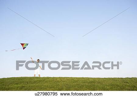 Young boy flying kite in a field View Large Photo Image Stock Photography - Young boy flying kite in a field. Fotosearch