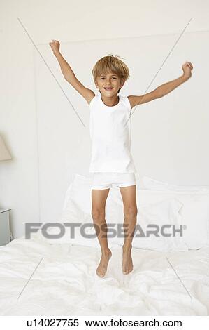 Stock Photography - Young Boy Jumping On Bed. Fotosearch