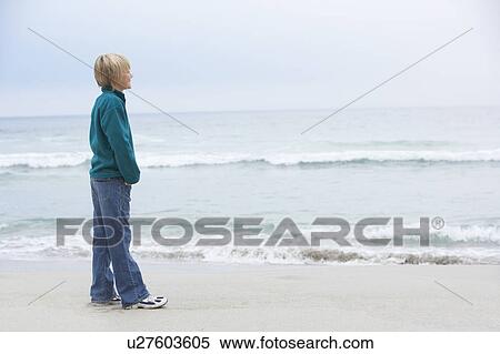 Young Boy On Holiday Standing On Winter Beach Looking Out To Sea View Large Photo Image Stock Photography - Young Boy On Holiday Standing On Winter Beach Looking Out To Sea. Fotosearch