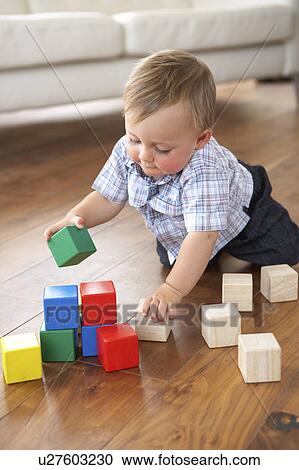 Stock Image - Young Boy Playing With Coloured Blocks At Home. Fotosearch