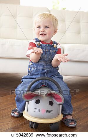Stock Photo - Young Boy Playing With Ride On Toy Mouse At Home. Fotosearch