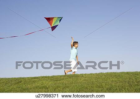 Young boy runs with kite through field View Large Photo Image Stock Image - Young boy runs with kite through field. Fotosearch
