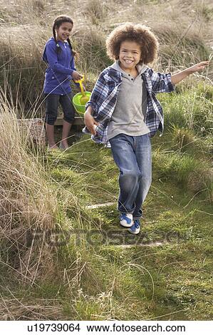 Picture - Young Children Carrying Fishing Net At Seaside. Fotosearch
