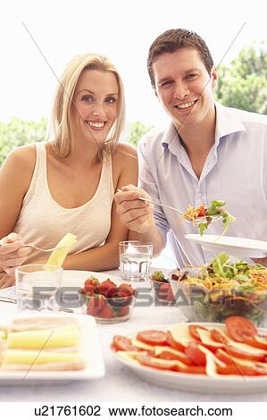 Young couple eating outdoors View Large Photo Image Stock Image - Young couple eating outdoors. Fotosearch