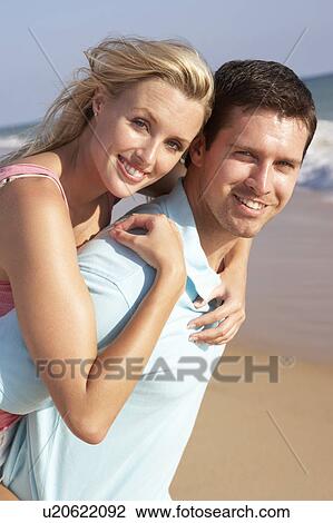 Stock Image - Young Couple Enjoying Beach Holiday. Fotosearch