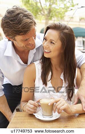 Stock Image - Young Couple Enjoying Coffee And Cake In Café. Fotosearch