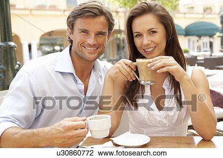 Stock Image - Young Couple Enjoying Coffee And Cake In Café. Fotosearch